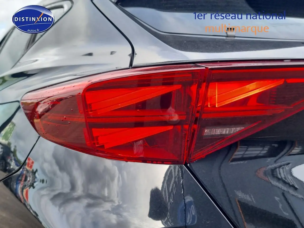 Gros plan sur le feu arrière droit rouge vif d'une CUPRA Formentor noir midnight 2025, reflet sur la carrosserie brillante.