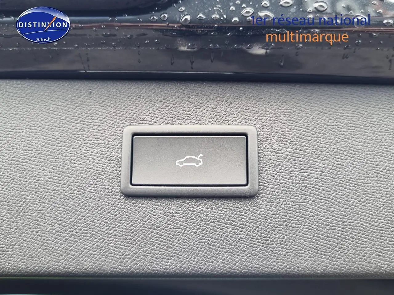 Bouton d'ouverture électrique du coffre sur tableau de bord noir texturé d'une CUPRA Formentor 2025 noir midnight.