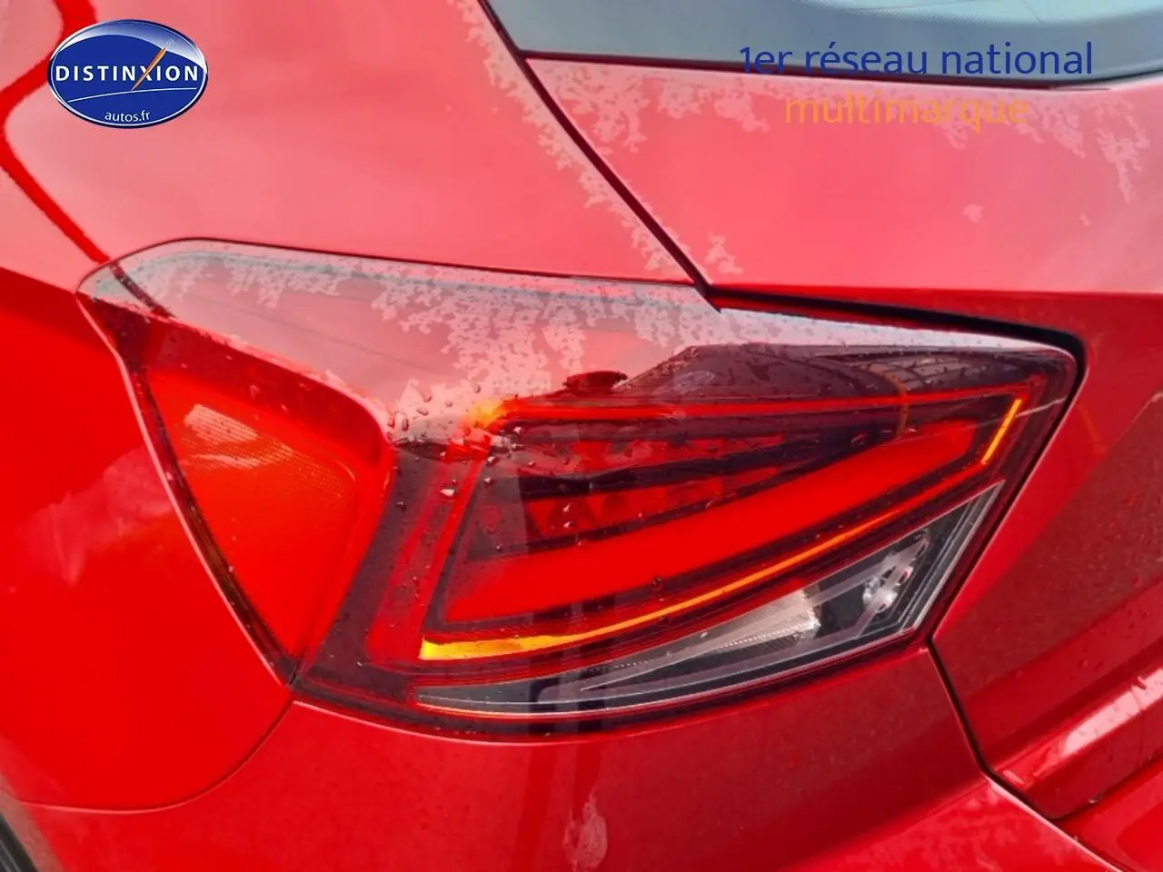 Gros plan sur le feu arrière droit rouge d'une SEAT Ibiza 2025 rouge désir avec détails lumineux modernes.