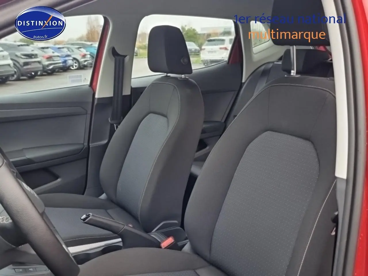 Vue intérieure côté gauche des sièges avant en tissu gris dans une SEAT Ibiza rouge désir 2025.