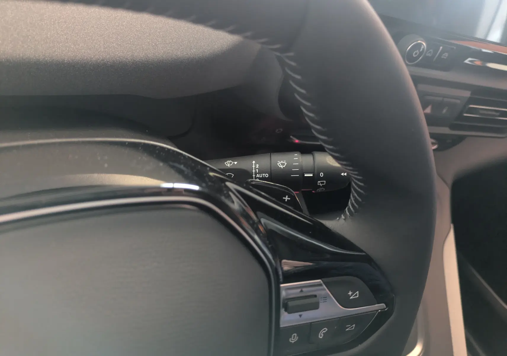 Gros plan sur le volant et la commande de régulateur de vitesse du Peugeot Rifter 2025, intérieur noir.