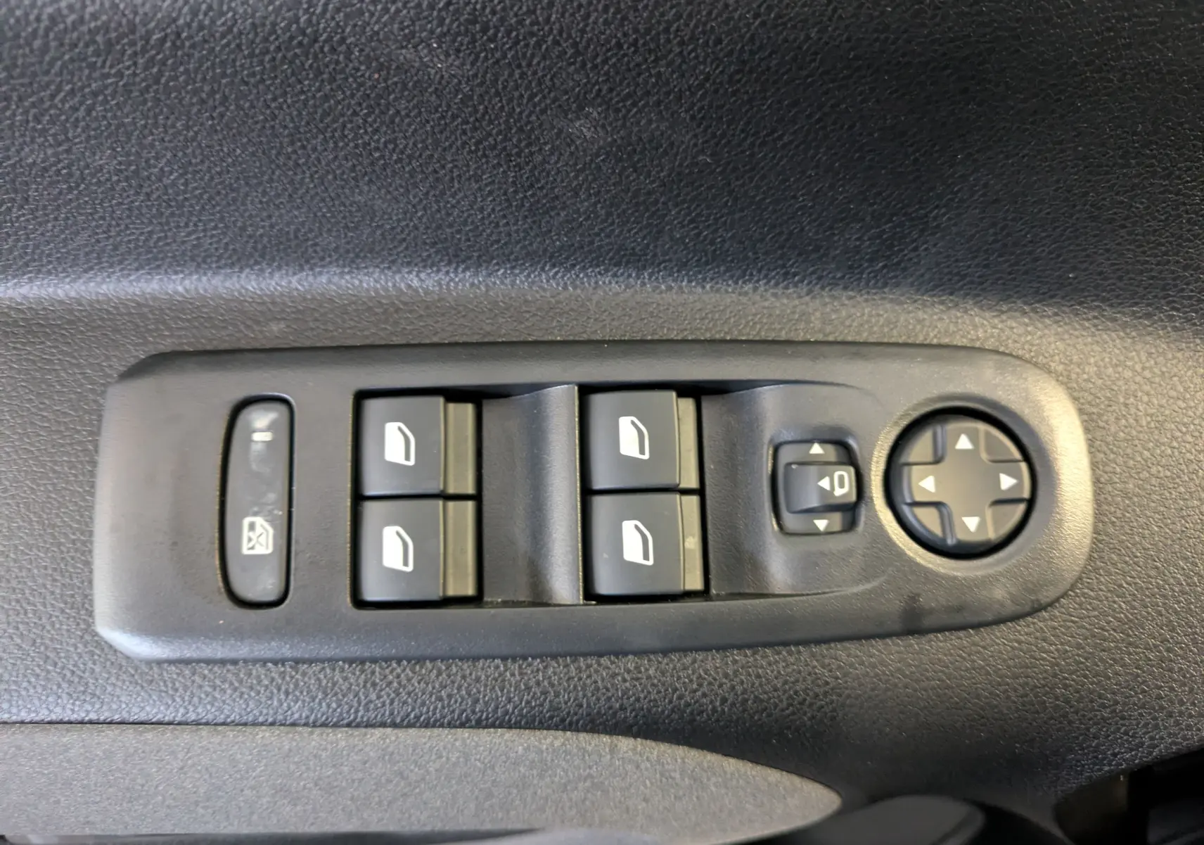 Panneau de commandes des vitres et rétroviseurs côté conducteur d’un Peugeot Rifter gris Artense 2025, finition Allure Pack Style.
