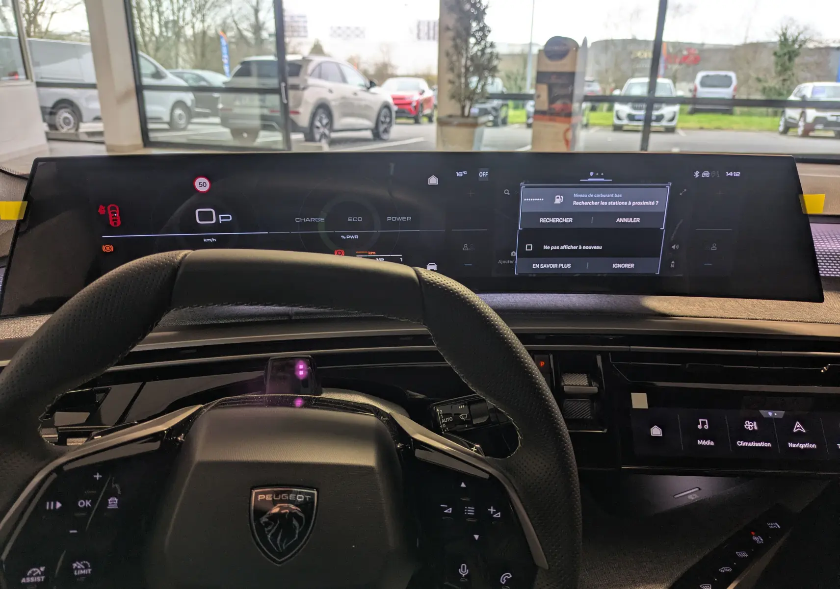 Vue intérieure du tableau de bord et volant du Peugeot 3008 blanc Okenite, avec écran numérique large et commandes au volant.