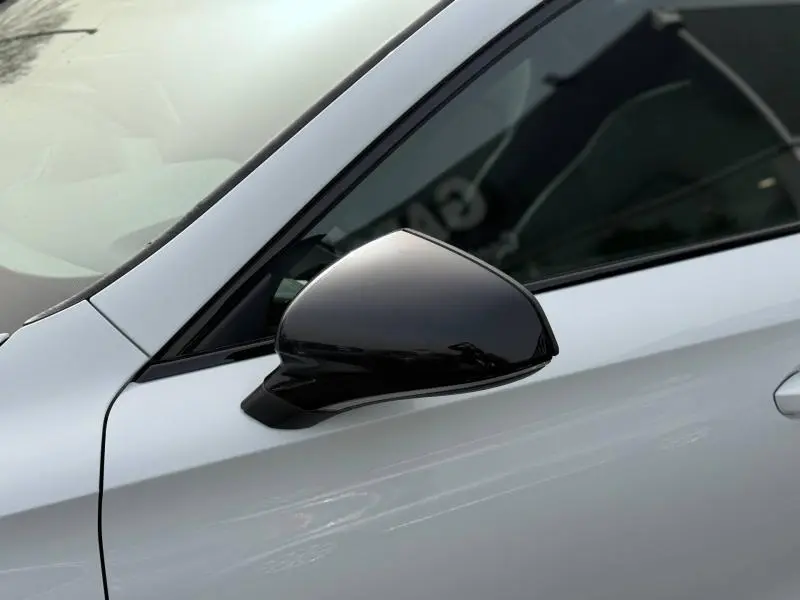 Gros plan sur le rétroviseur noir côté gauche d'une CUPRA Formentor blanc Nevada métallisé 2025.