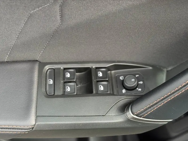 Gros plan sur les commandes de lève-vitres et réglage des rétroviseurs côté conducteur du CUPRA Formentor 1.5 eTSI Hybrid 2025.