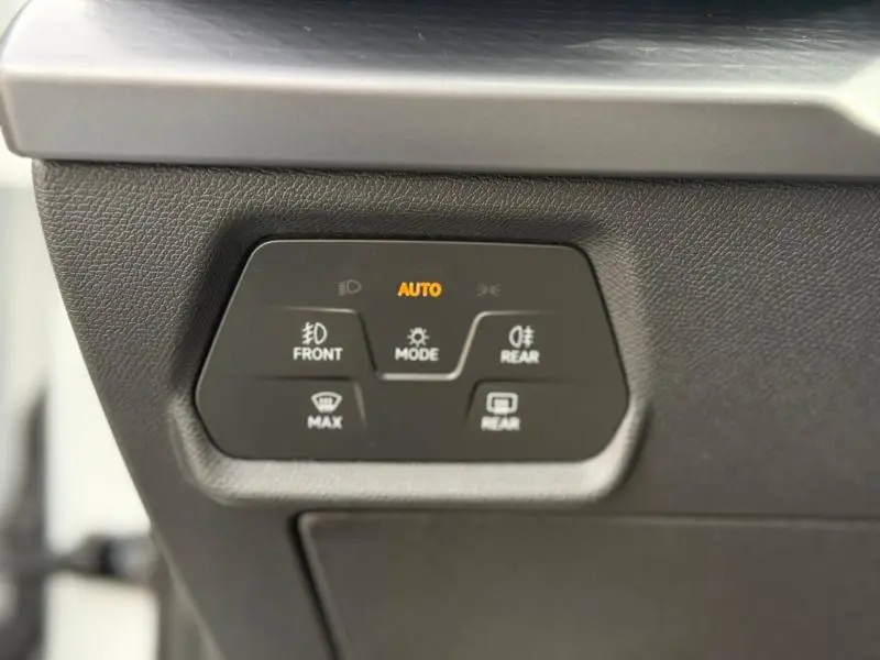 Gros plan sur les commandes d’éclairage du tableau de bord d’une CUPRA Formentor blanc Nevada métallisé, version hybride 2025.