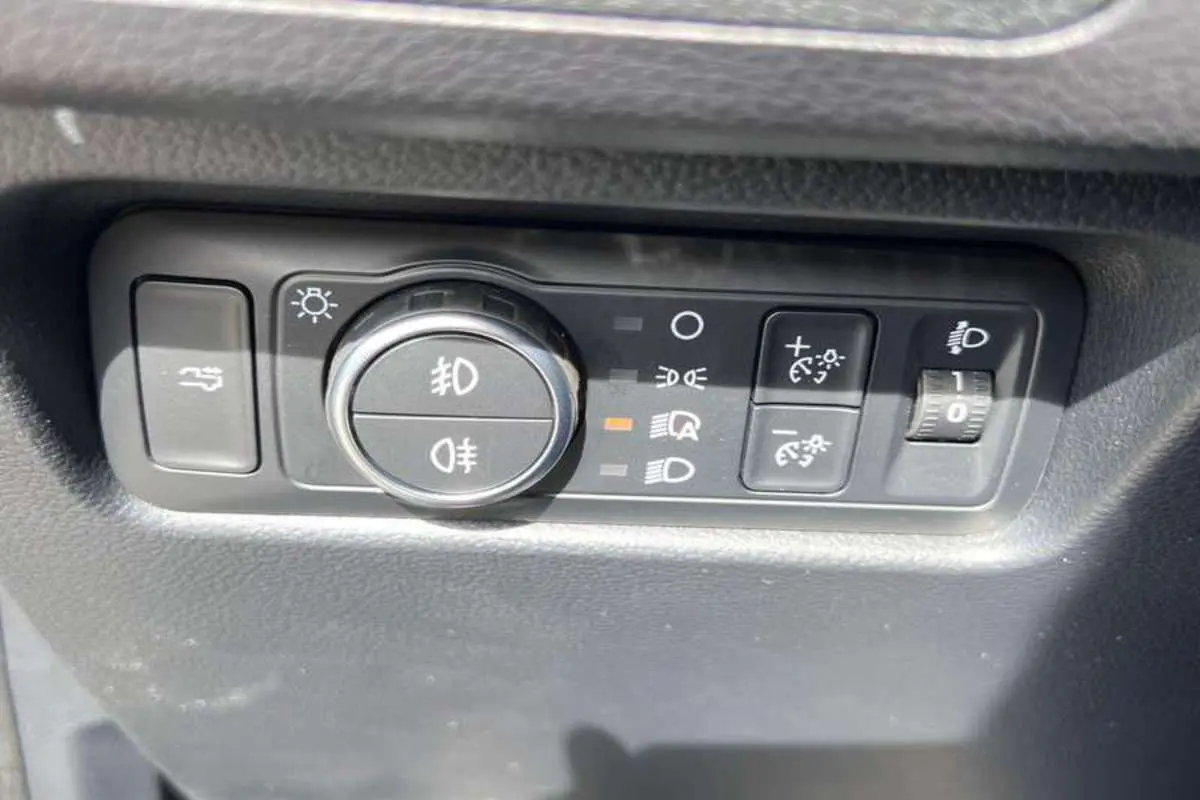 Gros plan sur les commandes d’éclairage et réglage de hauteur des phares du Ford Ranger noir agate 2026.