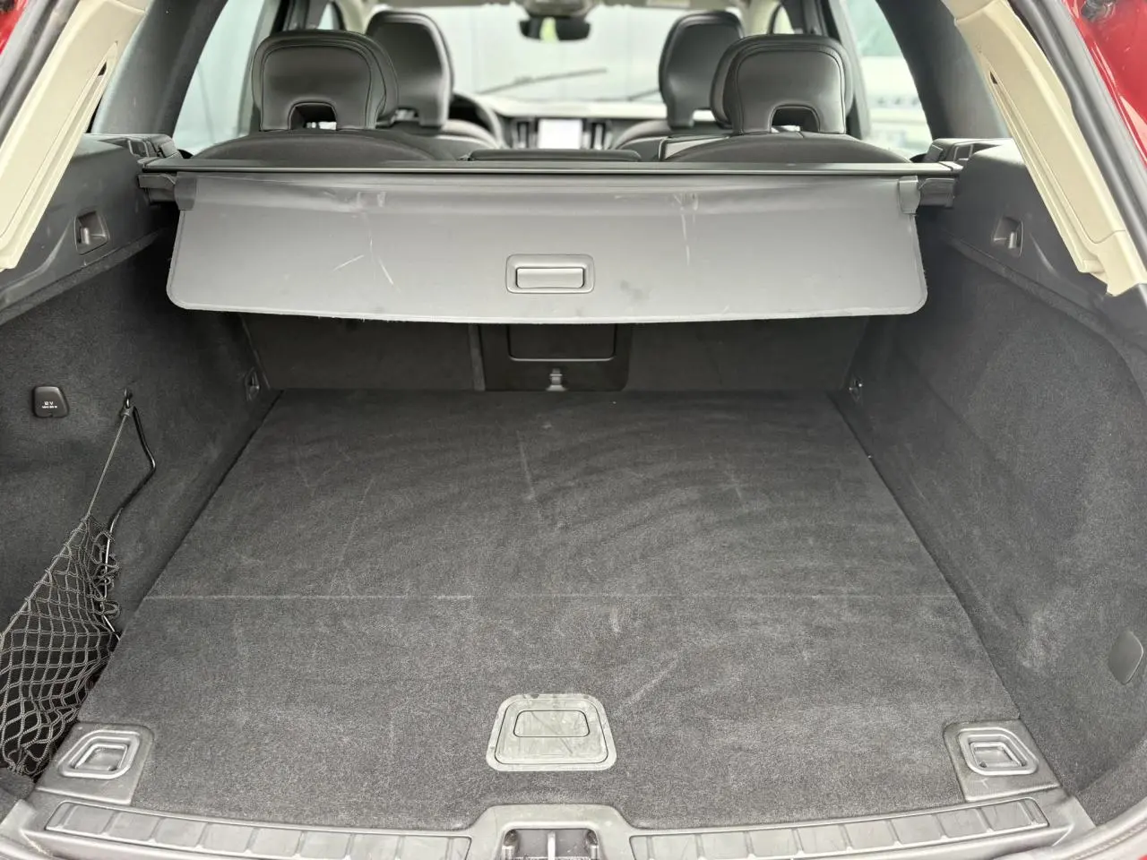 Vue arrière du coffre spacieux et tapis noir du Volvo XC60 T6 AWD PHEV 350 Plus Style Chrome rouge Fusion 2024.