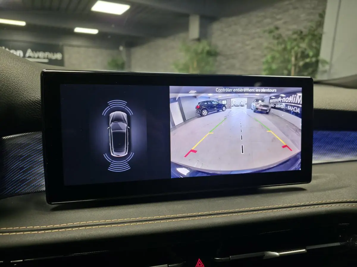 Écran intérieur affichant la caméra de recul et les capteurs de stationnement d’une Alfa Romeo Tonale bleu, vue avant.