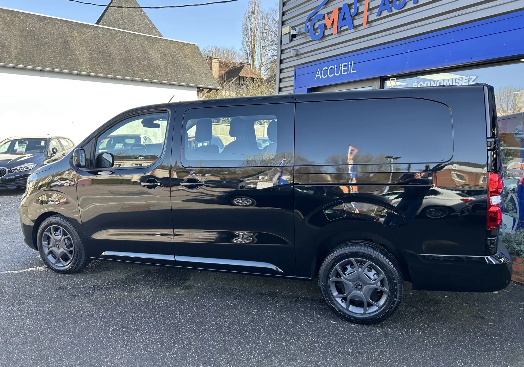 Vue de profil côté gauche d’un Citroën Jumpy Cabine Approfondie noir avec jantes tôle 17 pouces et porte latérale coulissante.