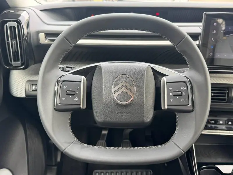 Vue rapprochée du volant multifonction noir de la Citroën C3 1.2 Turbo 100ch MAX 2025, avec tableau de bord gris Mercury.