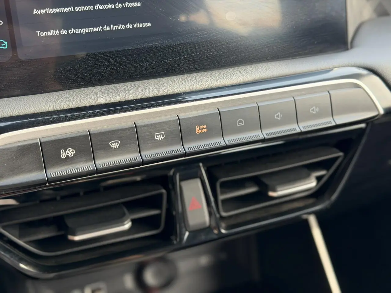 Gros plan sur la console centrale du MG3 1.5 Hybrid+ 195 Comfort, montrant les commandes de climatisation et les aérateurs noirs.