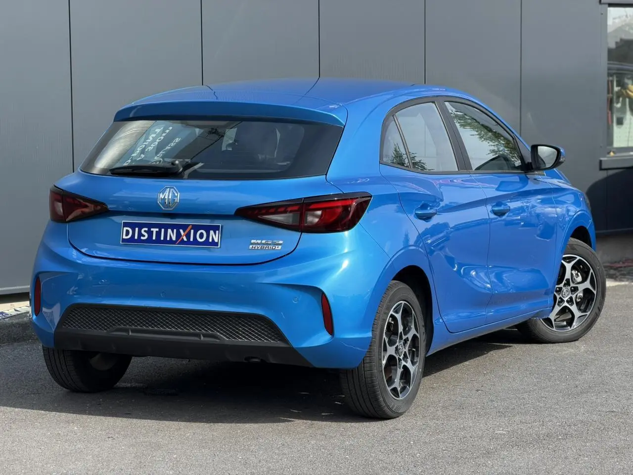 Vue 3/4 arrière droite d'une MG3 1.5 Hybrid+ 195 Comfort bleu Como avec jantes alliage et feux arrière LED.