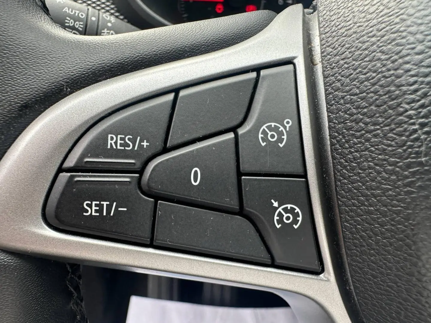 Gros plan sur les commandes de régulateur de vitesse noires sur le volant du Dacia Jogger 2025.