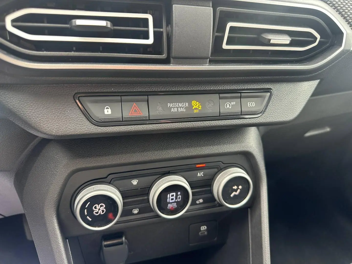 Détail de la console centrale du Dacia Jogger 2025 avec commandes climatisation et boutons fonctionnels en noir mat.