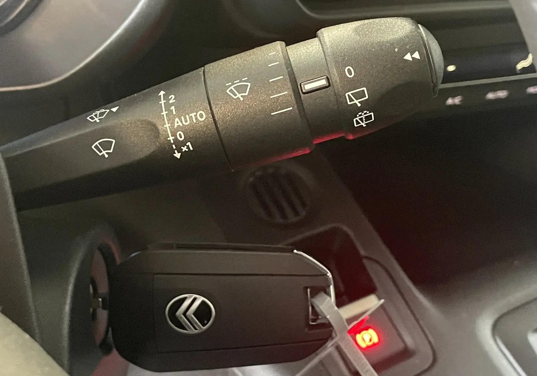 Gros plan sur la commande d’essuie-glace et la clé noire du Citroën Berlingo 2025 visible dans l’habitacle.