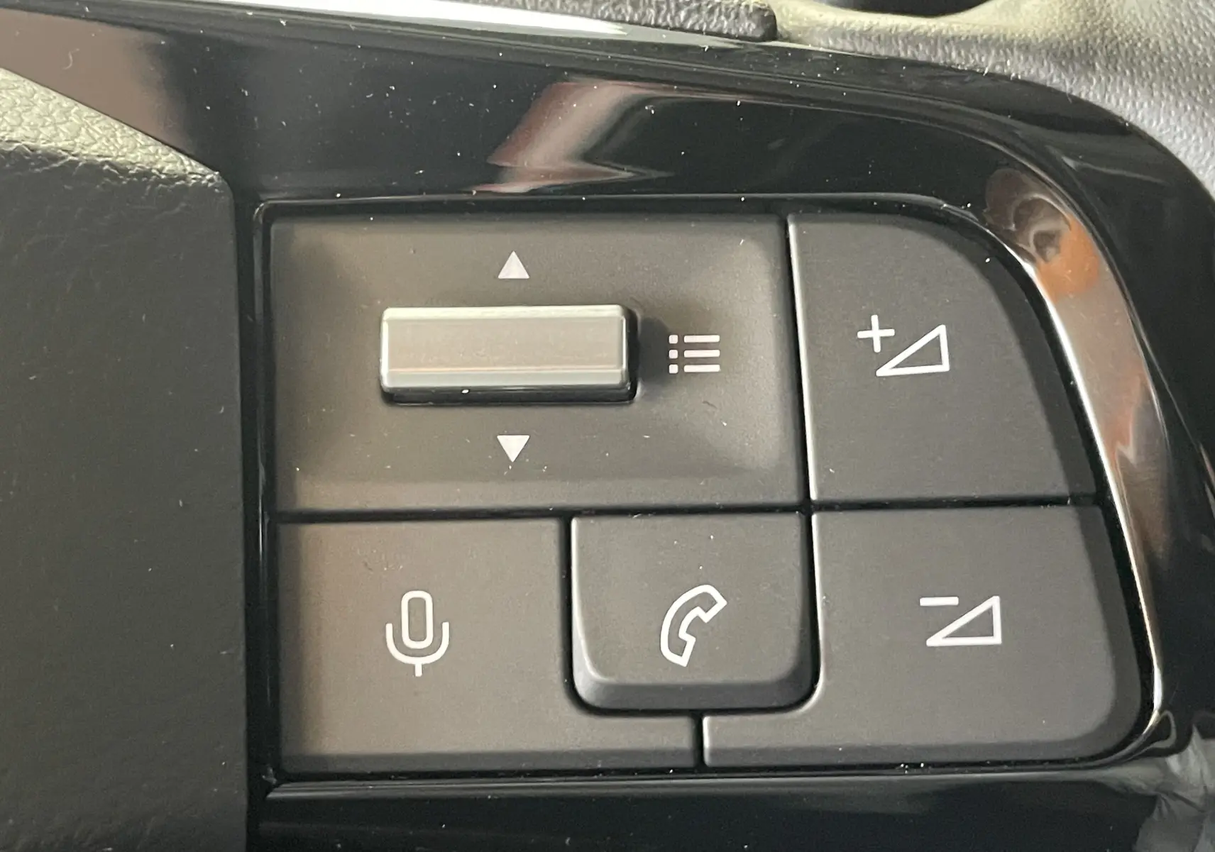 Gros plan sur les commandes au volant du Citroën Berlingo noir 2025, boutons de volume et téléphone visibles.