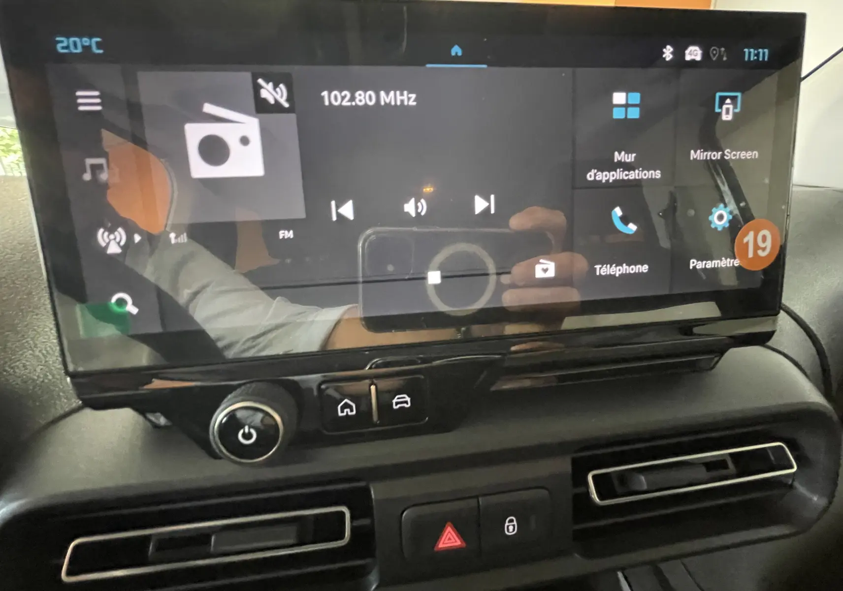 Écran tactile central du tableau de bord du Citroën Berlingo 2025 noir, affichant la radio FM et les options connectées.