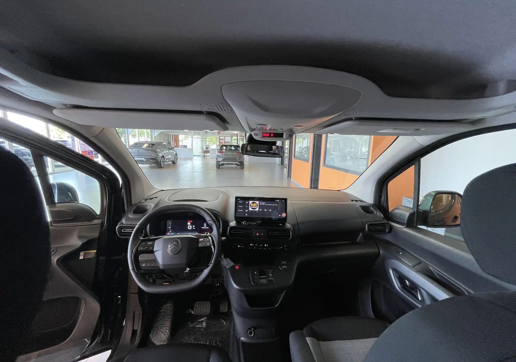 Vue intérieure avant du Citroën Berlingo noir 2025, mettant en valeur le tableau de bord et l'écran tactile central.