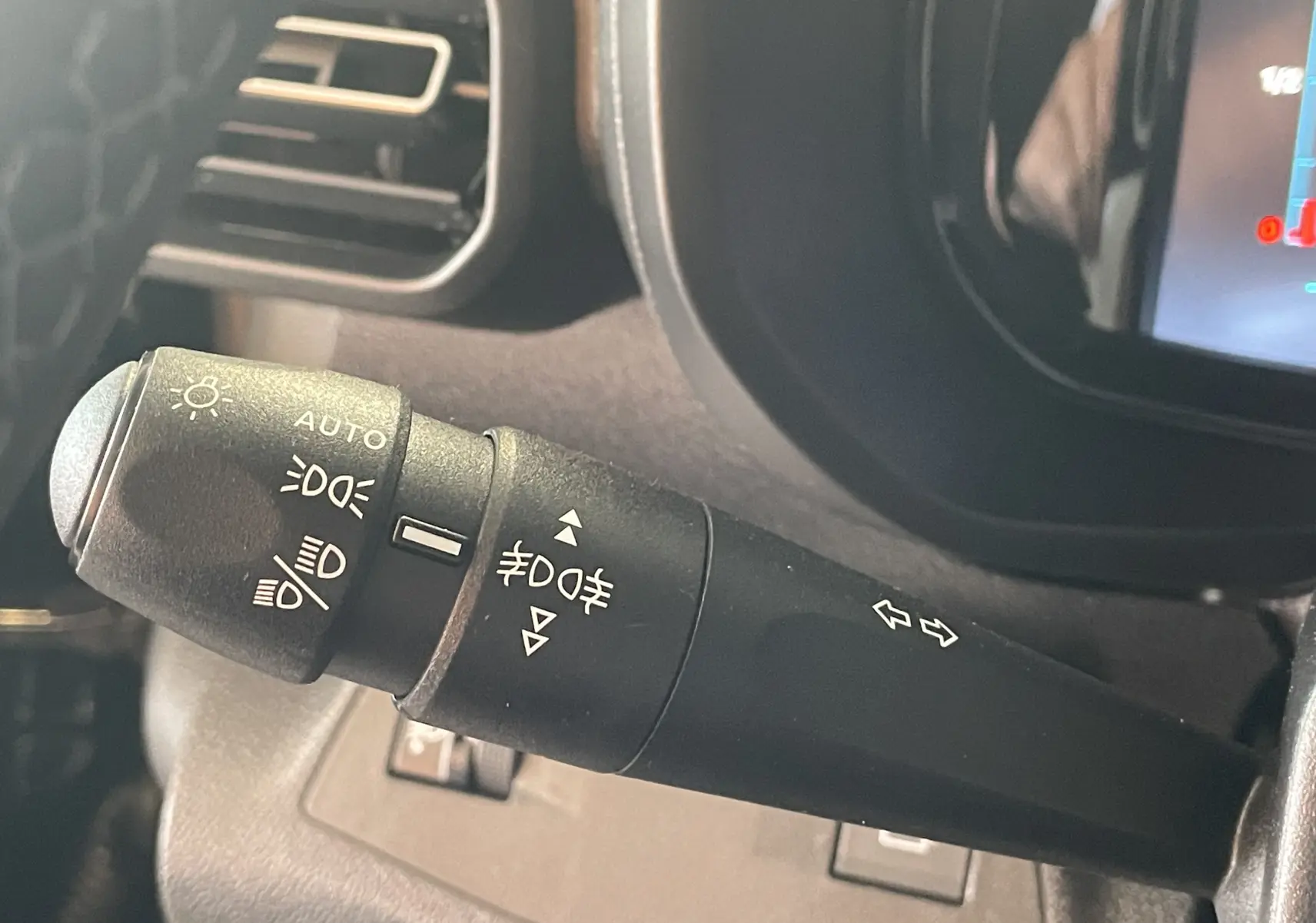 Gros plan sur la commande des phares et clignotants à gauche du volant dans un Citroën Berlingo noir 2025.