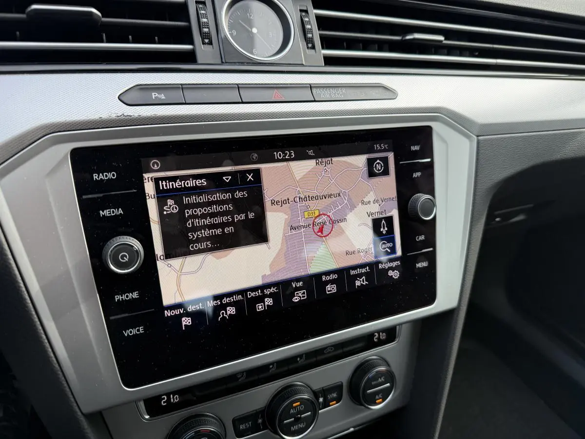 Écran tactile central avec navigation active dans l'habitacle d'une Volkswagen Passat noire, vue rapprochée.