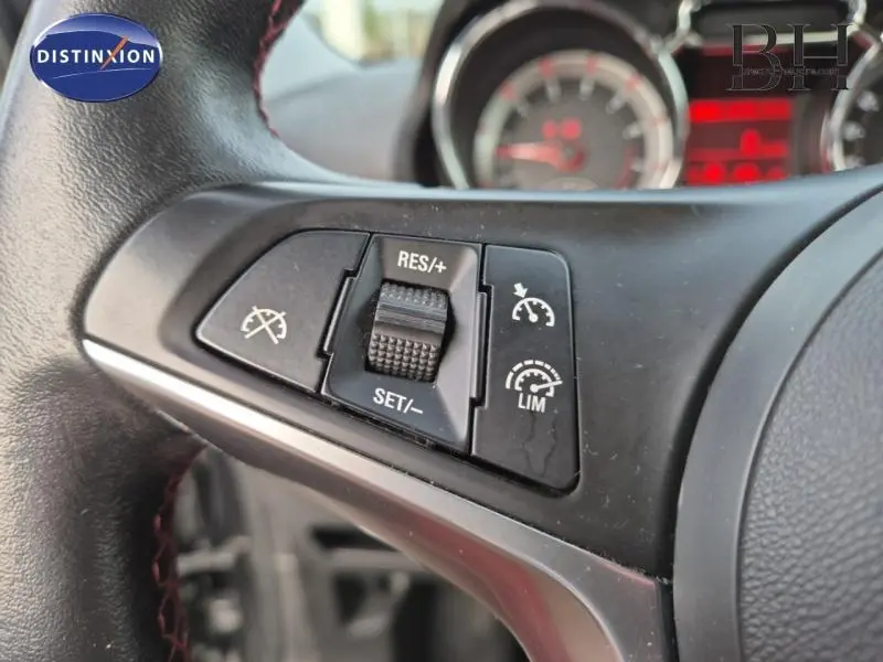 Gros plan sur les commandes de régulateur de vitesse au volant cuir noir de l'Opel Adam Rocks 2016.