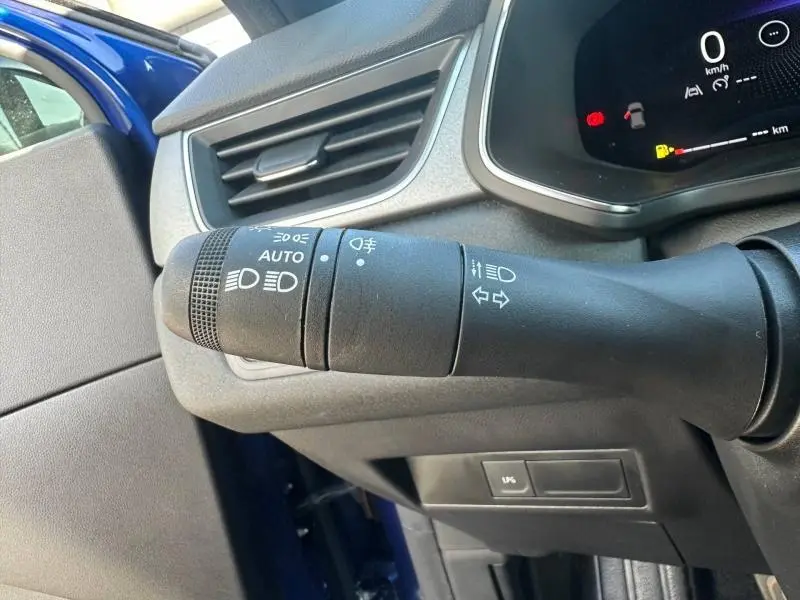 Gros plan sur la commande des phares à gauche du volant du Renault Captur 2025 Bleu Iron/Noir Étoilé, intérieur noir.