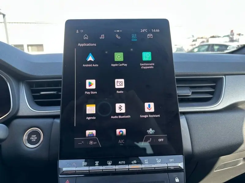 Écran tactile central allumé du Renault Captur 2025, vue intérieure frontale avec commandes climatisation visibles.