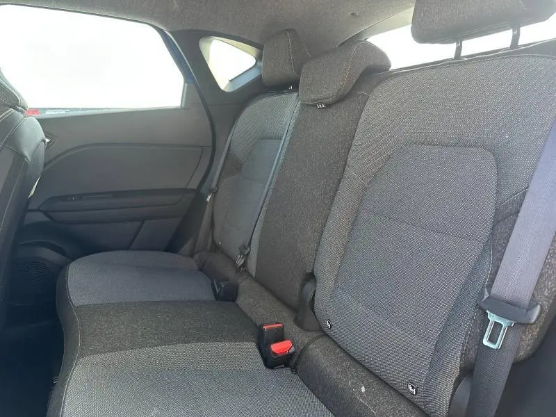 Vue intérieure côté droit des sièges arrière gris foncé du Renault Captur 2025 avec appuie-têtes et ceintures visibles.