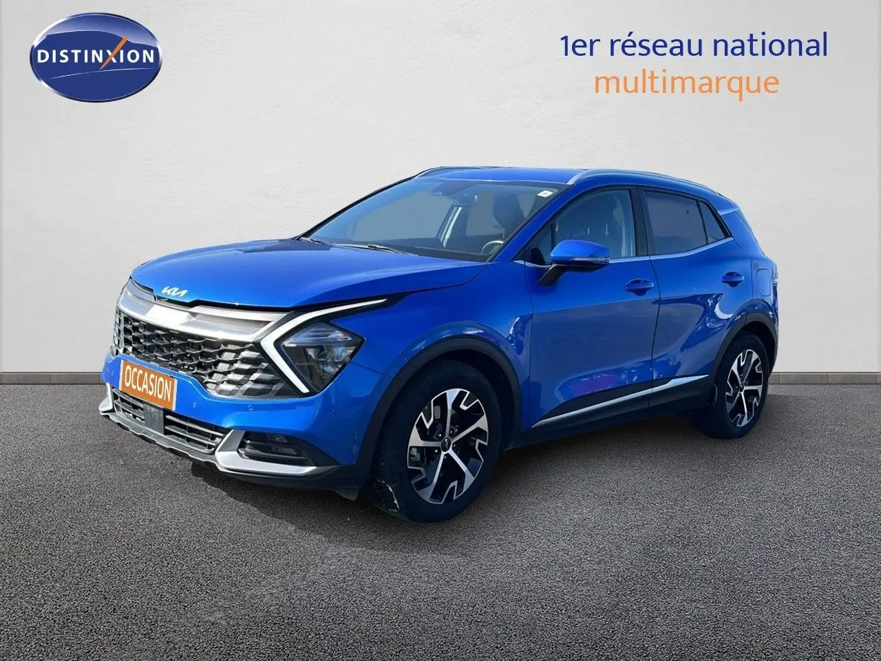 KIA SPORTAGE bleu fusion métal en 3/4 avant droit, avec calandre distinctive et jantes noires à motifs.