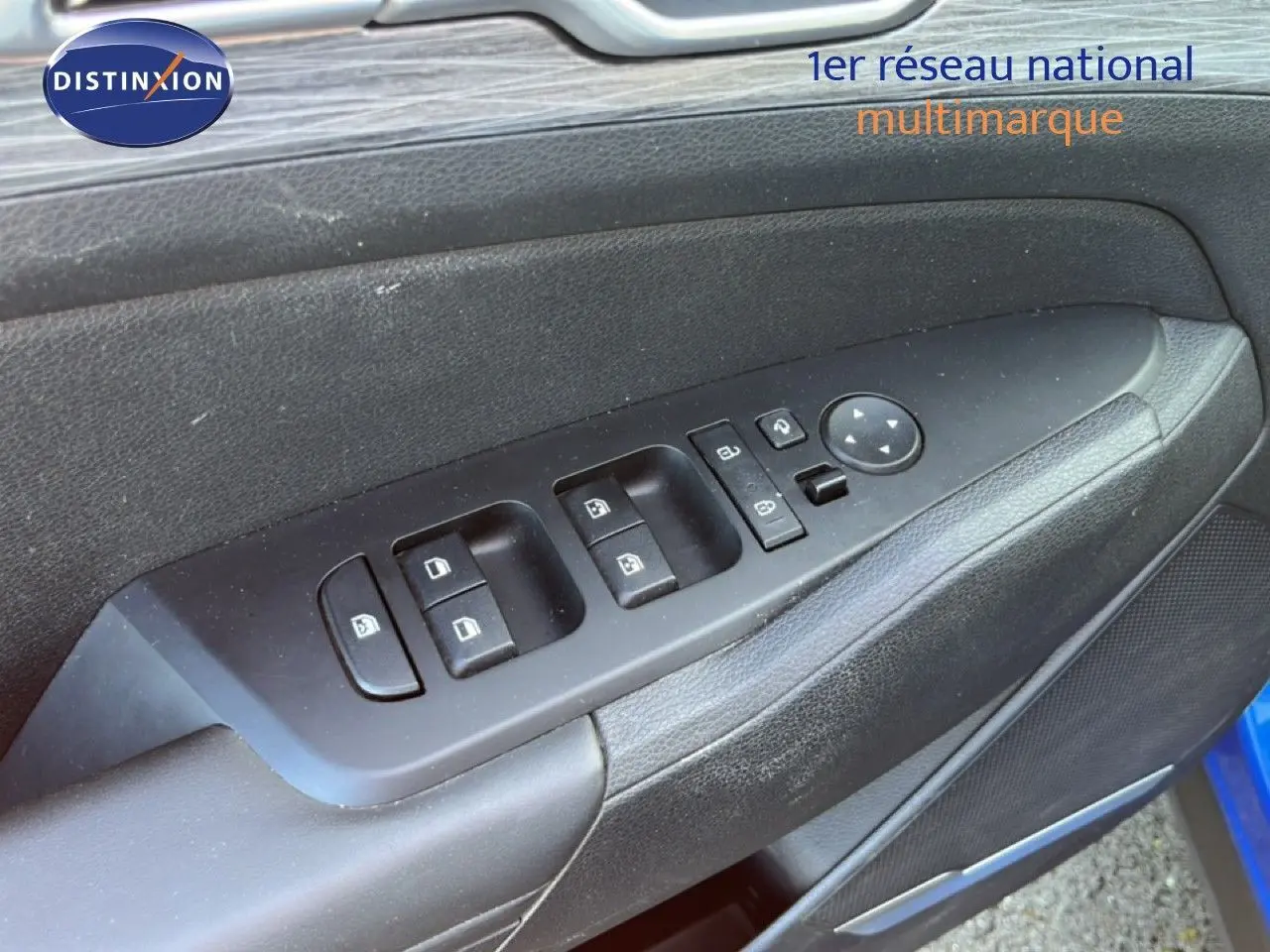 Gros plan sur la commande des vitres et rétroviseurs côté conducteur du Kia Sportage bleu fusion métal 2022.