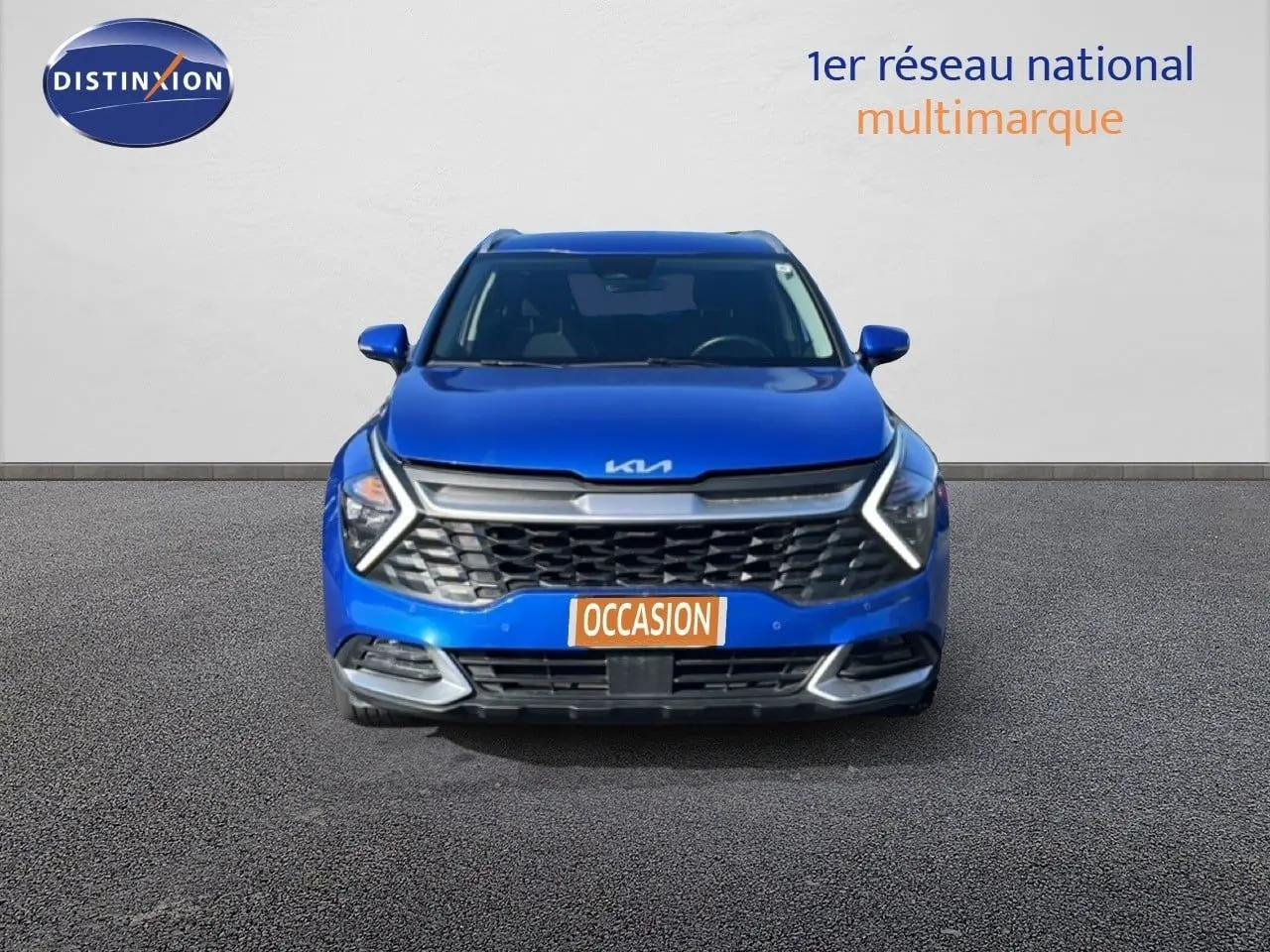 Vue frontale d'un Kia Sportage bleu fusion métal 2022 avec calandre distinctive et feux LED en forme de flèche.