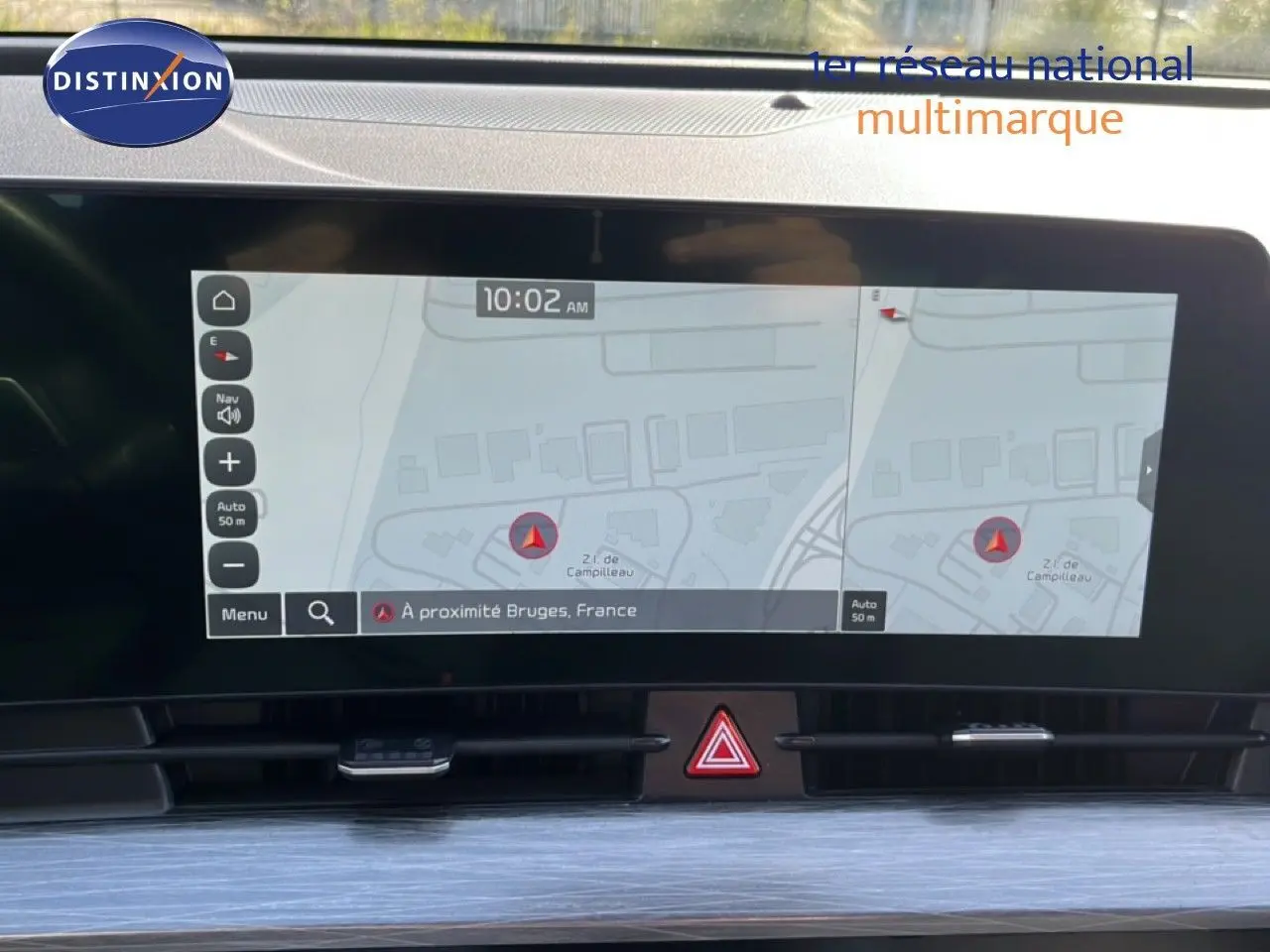 Écran tactile central du Kia Sportage 2022 affichant la navigation avec carte et alertes, intérieur moderne en noir.