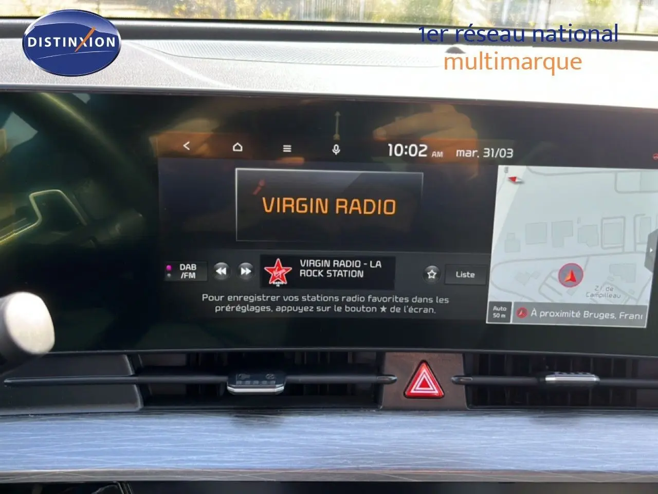 Vue rapprochée de l’écran central tactile du Kia Sportage 2022 bleu fusion, affichant la radio et la navigation.
