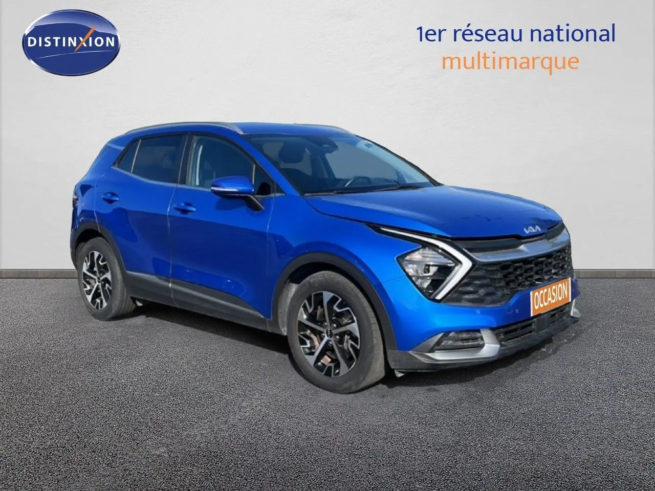 SUV KIA Sportage bleu fusion métal en 3/4 avant droit, avec calandre noire et jantes alliage bicolores.