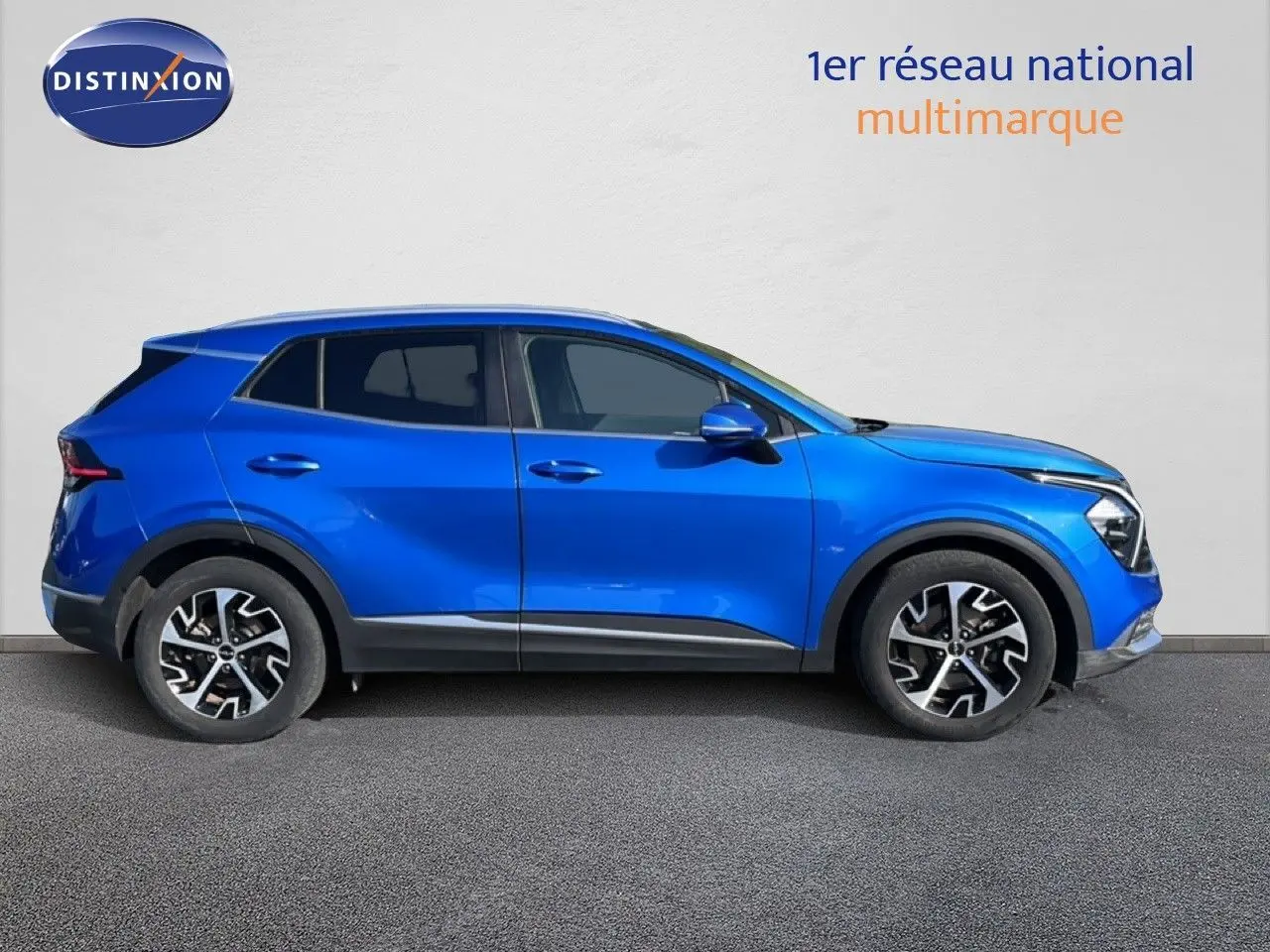 Vue latérale droite d'un Kia Sportage bleu fusion métal 2022 avec jantes alliage et lignes modernes.