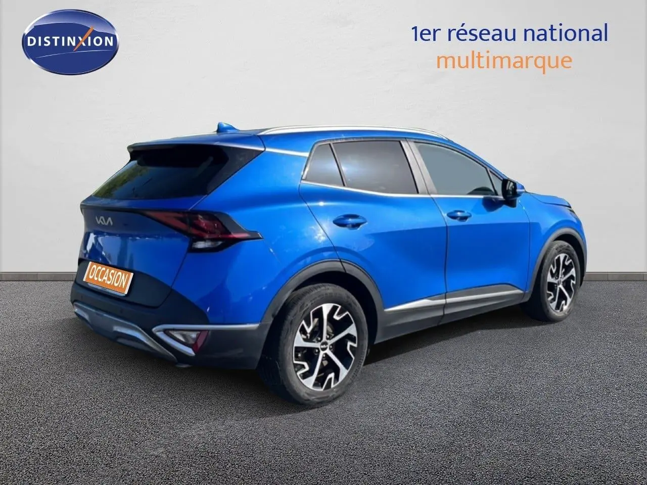 KIA SPORTAGE bleu fusion métal en 3/4 arrière droit, avec jantes alliage noires et détails chromés.