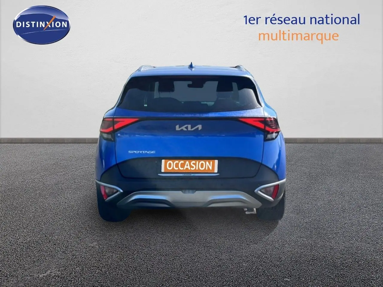 Vue arrière d'un KIA Sportage bleu fusion métal 2022 avec feux arrière LED et plaque "OCCASION" visible.