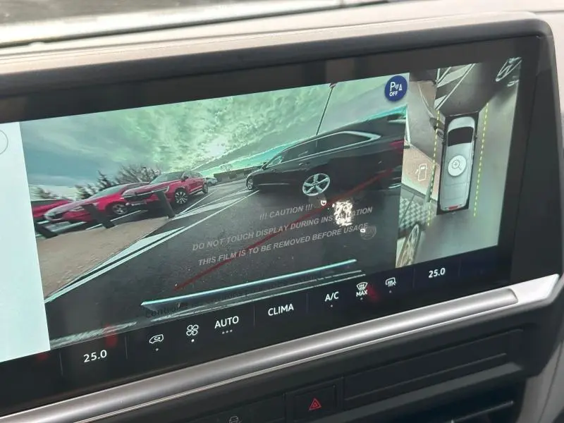 Écran tactile affichant la caméra de recul et vue 360° du Volkswagen Transporter gris en stationnement.