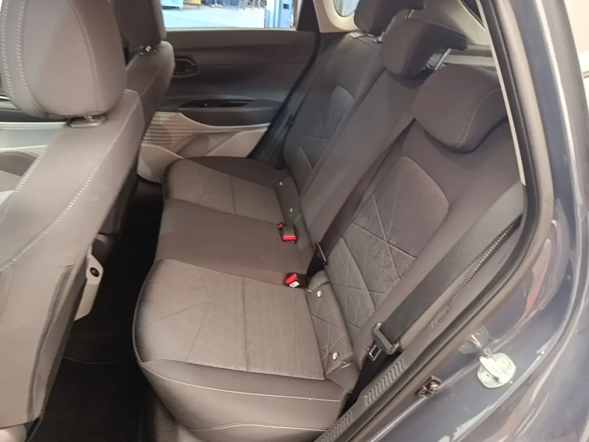 Vue intérieure côté droit des sièges arrière gris foncé du Hyundai Bayon 2023 avec ceinture de sécurité visible.