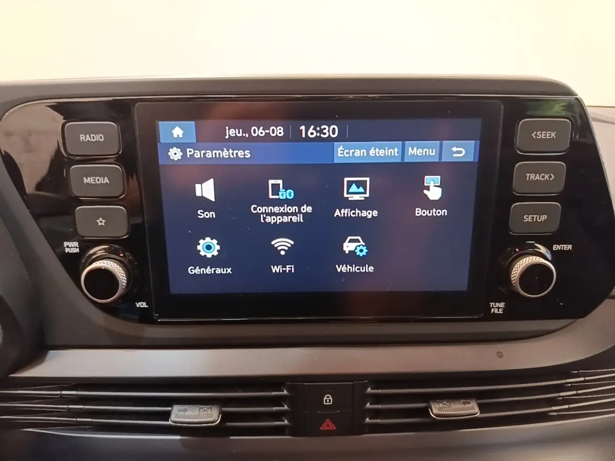 Écran tactile central de la Hyundai Bayon 2023 affichant le menu des paramètres, entouré de boutons de contrôle.