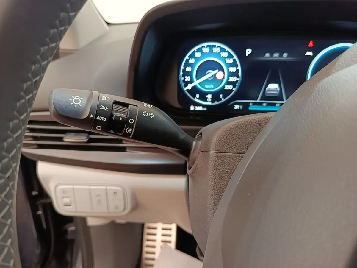 Vue rapprochée du commodo gauche et du combiné d'instruments numérique bleu dans l'habitacle du Hyundai Bayon 2023.