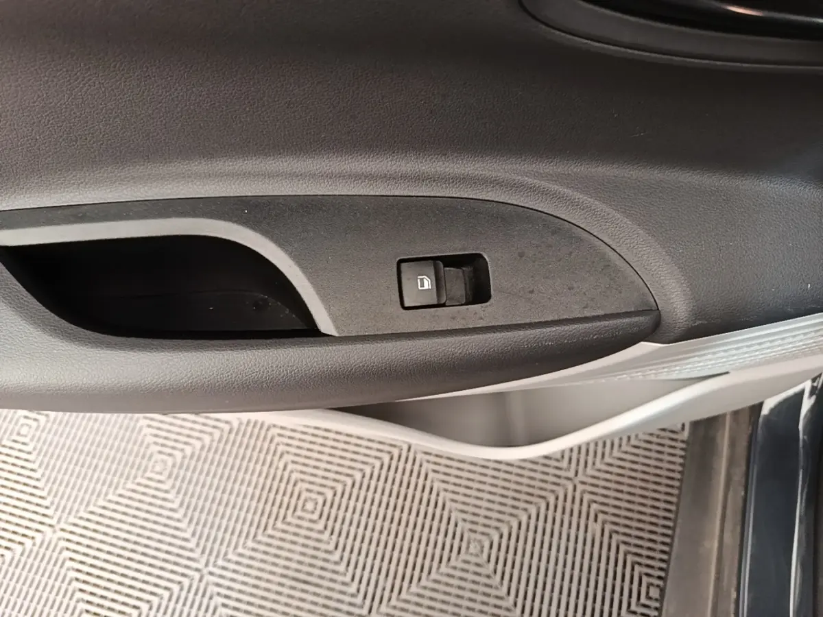Gros plan sur la poignée intérieure de porte côté conducteur d'une Hyundai Bayon gris foncé avec bouton de verrouillage.