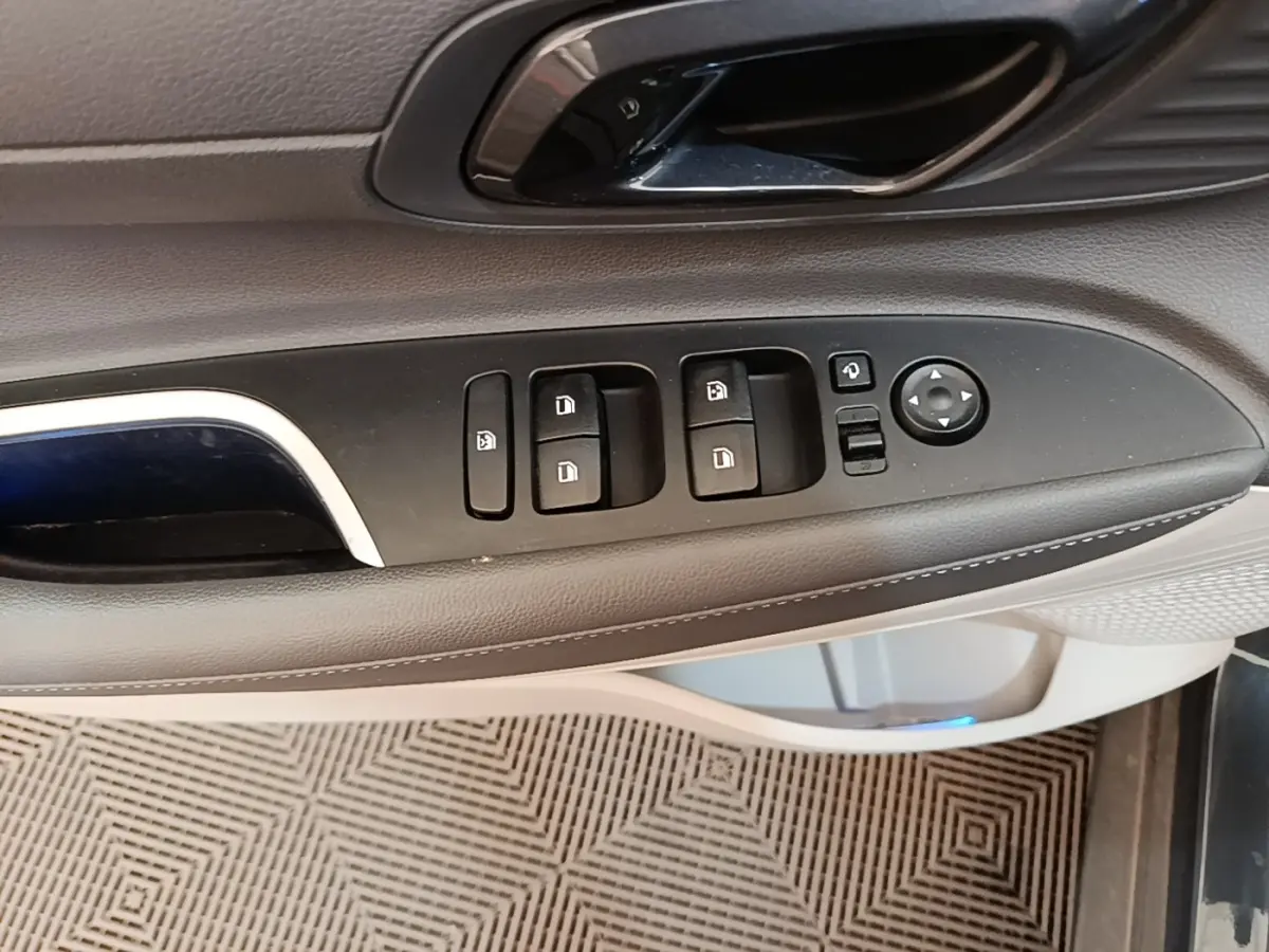 Gros plan sur la commande des vitres et rétroviseurs côté conducteur de la Hyundai Bayon 2023, intérieur gris et noir.