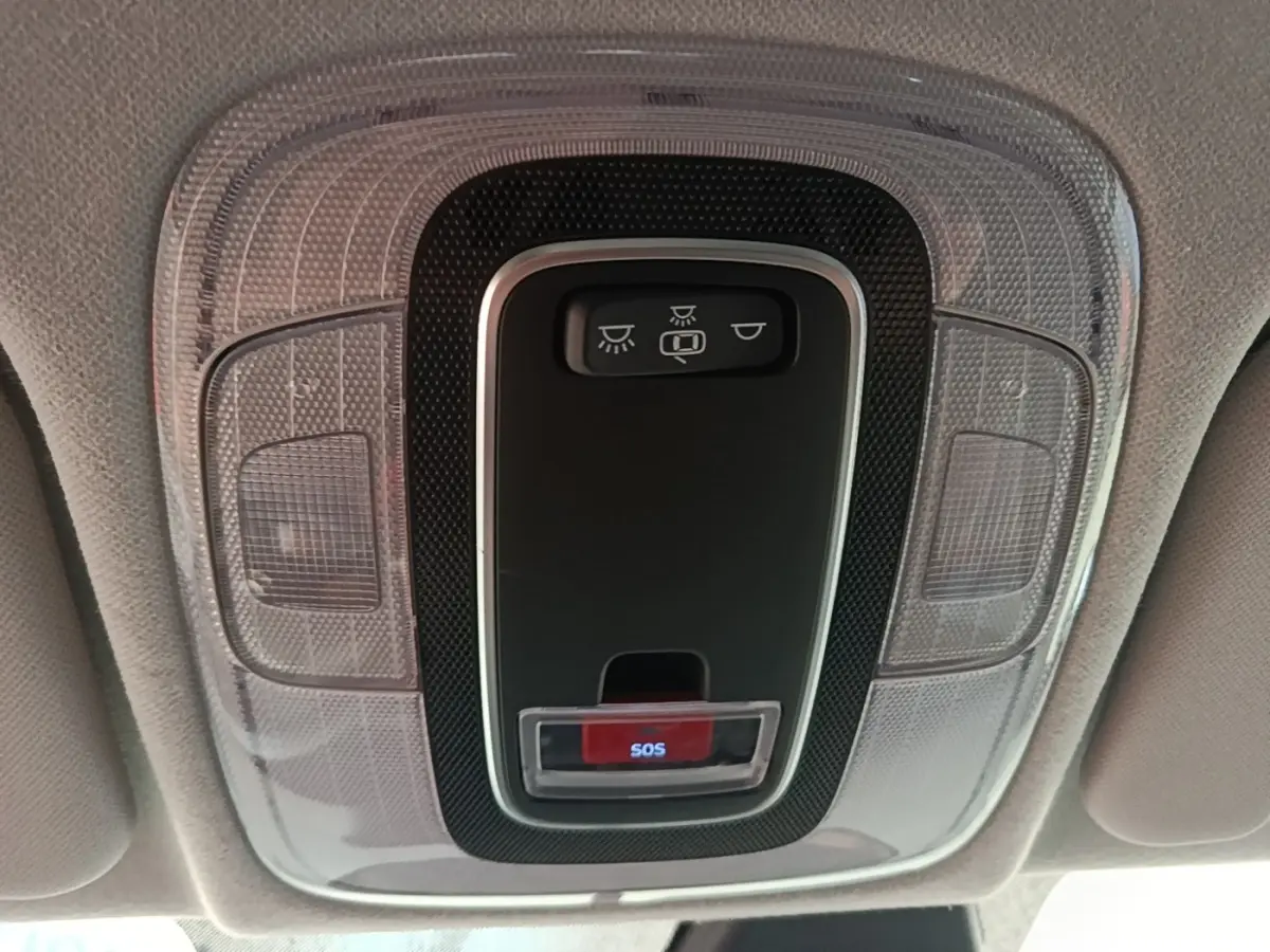 Gros plan sur la console de toit gris clair avec bouton SOS rouge et commandes d’éclairage dans une Hyundai Bayon 2023.