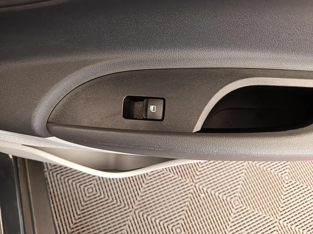 Gros plan sur la commande de verrouillage de porte côté gauche intérieur d'une Hyundai Bayon gris foncé 2023.