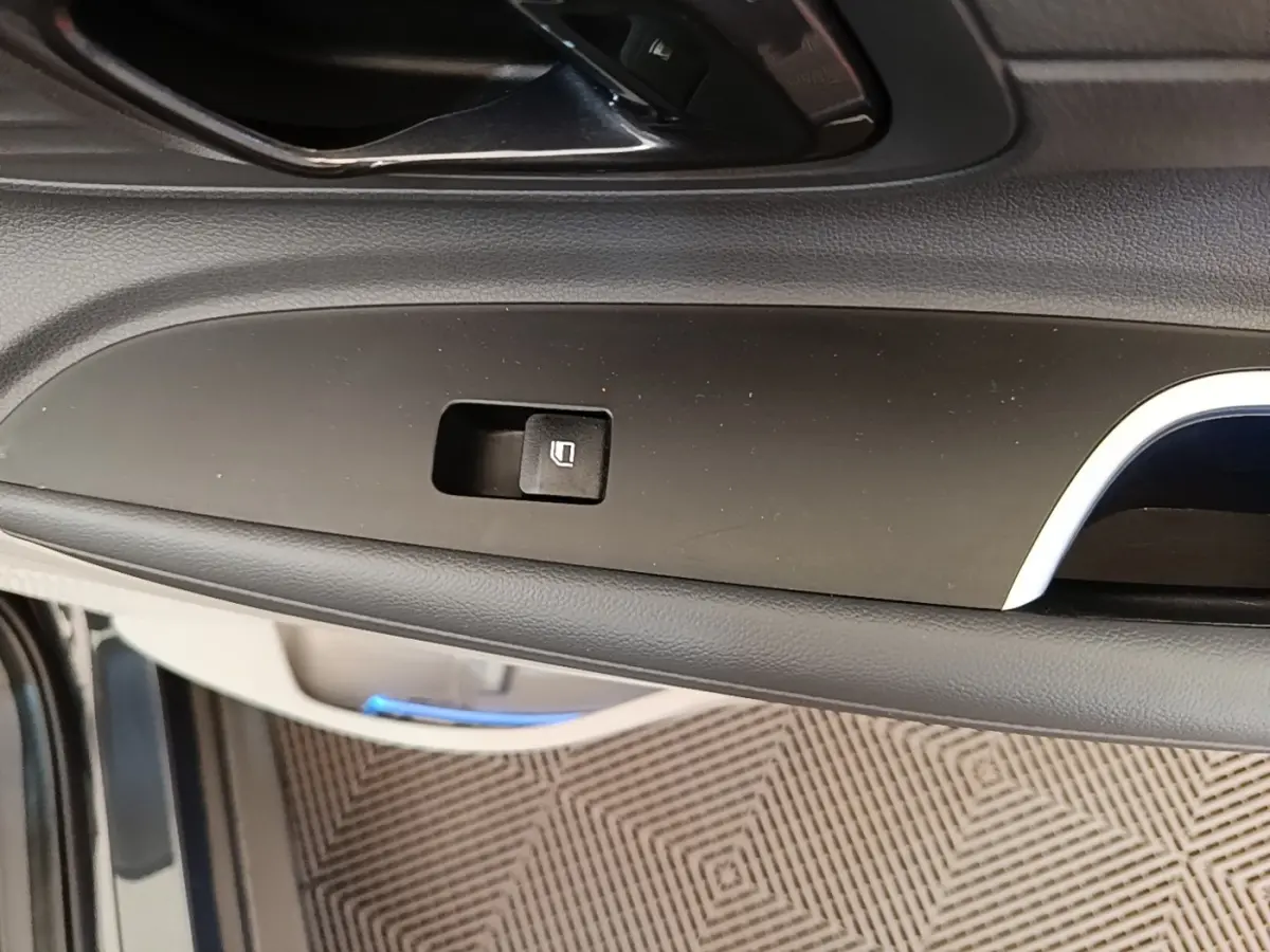Gros plan sur la commande de verrouillage de porte côté intérieur d’une Hyundai Bayon 2023, finition noire.