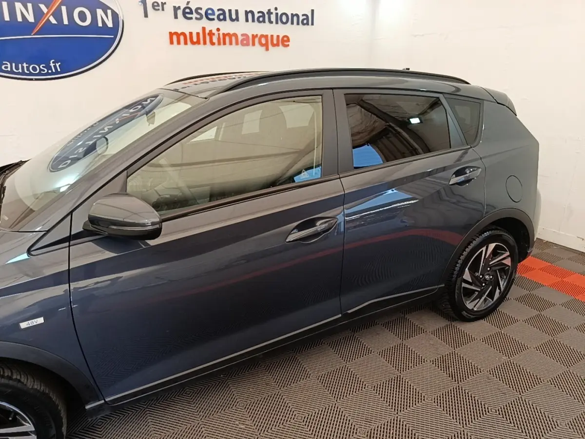 Vue latérale côté gauche d'une Hyundai Bayon gris foncé avec jantes alliage et vitres teintées.