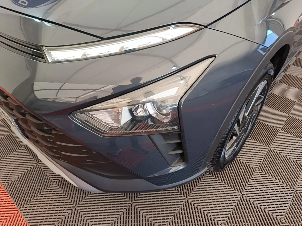 Gros plan sur l'avant droit gris foncé du Hyundai Bayon 2023, mettant en valeur le phare et la calandre.
