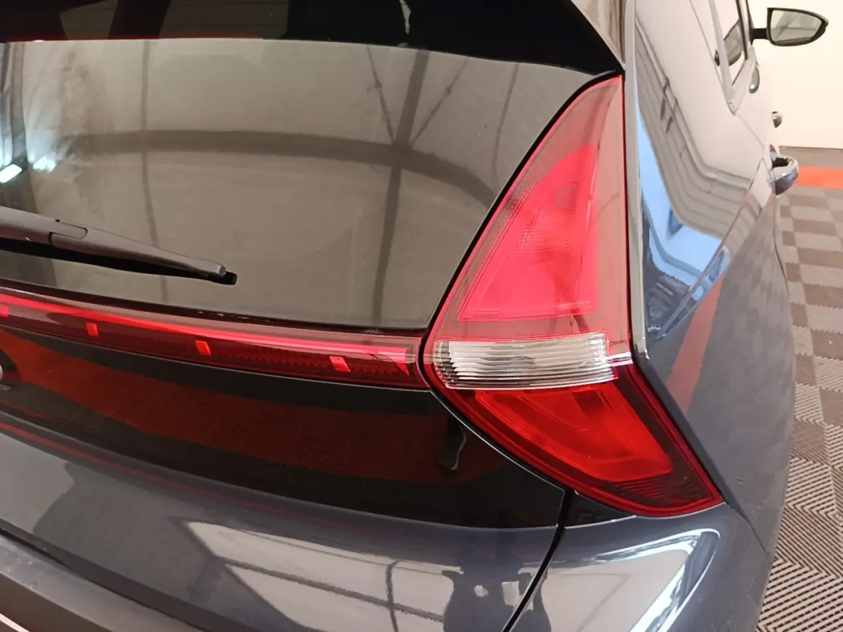 Gros plan sur le feu arrière droit d’une Hyundai Bayon gris foncé 2023, avec lunette arrière et essuie-glace visibles.